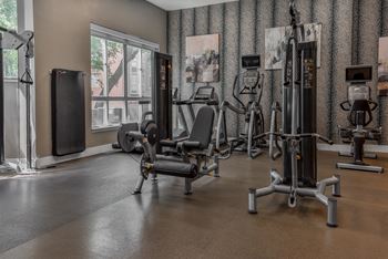 a gym with weights and cardio equipment in a room with a window at The Pointe at St. Joseph Apartments, South Bend, Indiana